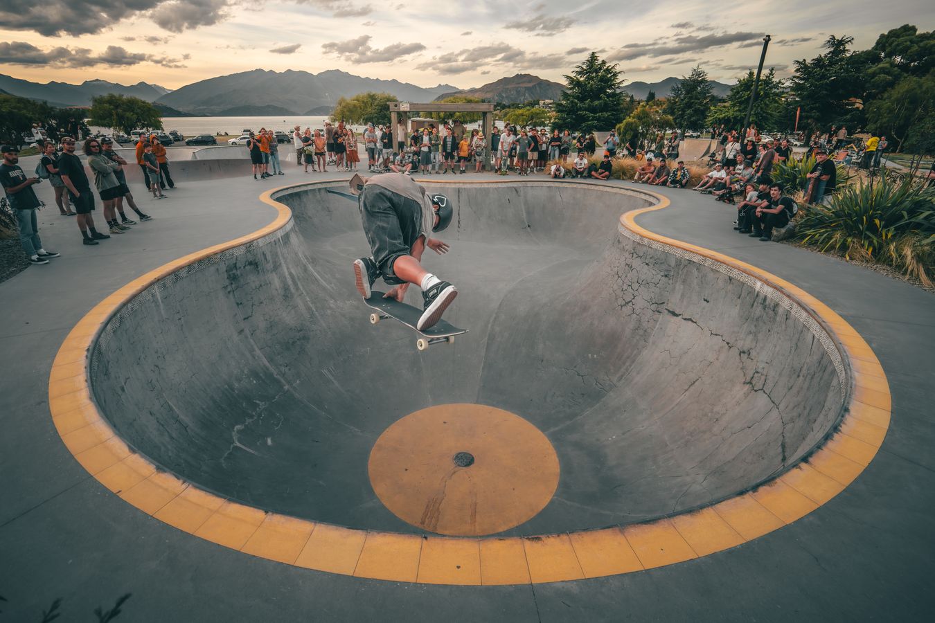 Skater airing in a bowl ringed in yellow with a crowd around it