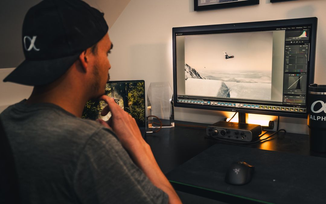 Blake at his desk editing a snowboard photo in Lightroom